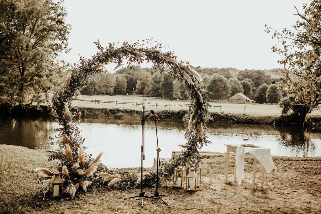 White ivory and sage floral wedding arch overlooking Brandywine River after hurricane 2021 in West Chester PA