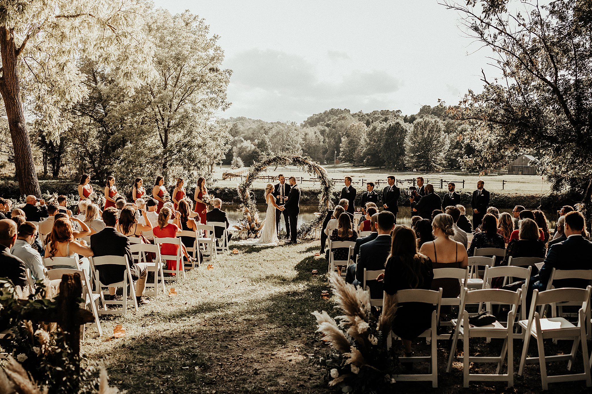 White ivory and sage floral wedding arch overlooking Brandywine River after hurricane 2021 in West Chester PA