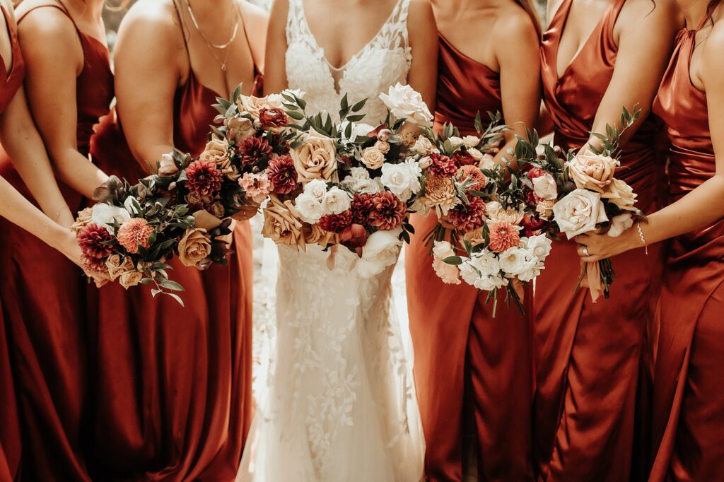 Bridesmaids pre-wedding portraits displaying beautiful hand dyed floral bouquets in burnt umber dresses