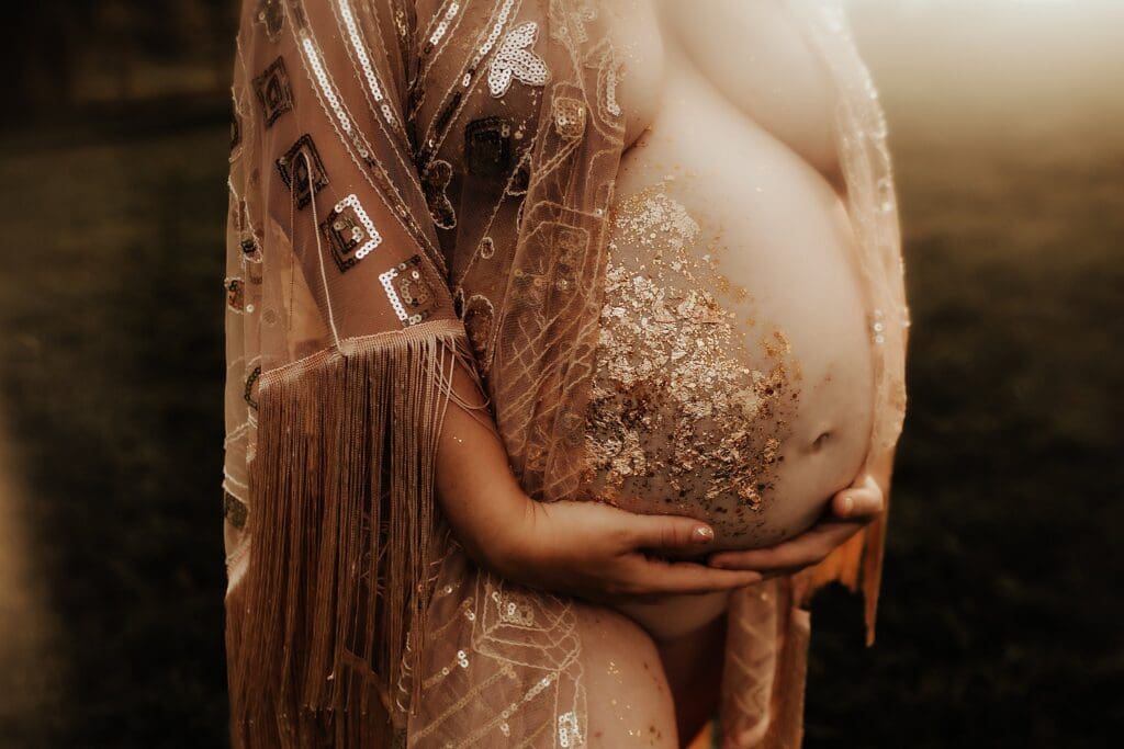 Woman holding her belly for an outdoor maternity photoshoot